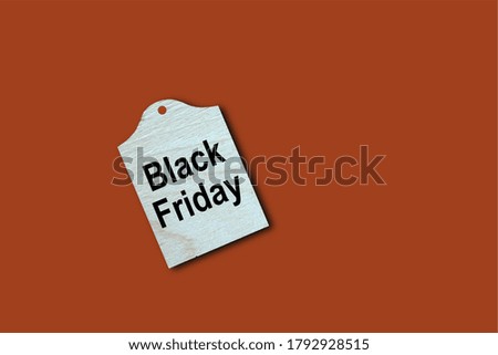 Wooden tag with Black Friday text on reddish brown background