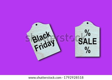 Wooden tags with Black Friday and Sale text on neon background
