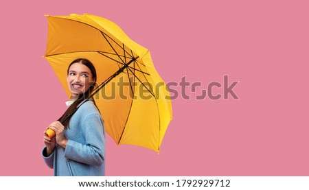 Fancy Girl. Portrait of fashionable girl carrying yellow parasol and looking back at copy space for you ad, logo or text