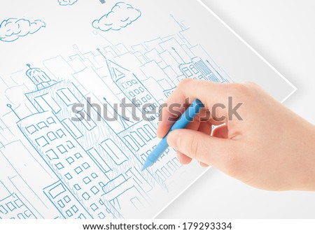A person drawing sketch of a city with balloons and clouds on a plain paper 