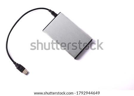 Gray external hard disk with black USB cable on white background.