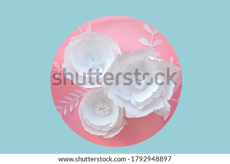 Handmade paper art and cut white flowers on pink and blue background. 