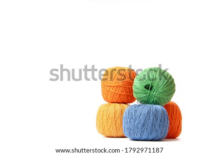 Colored balls of crochet thread on a white background . Copy space. The tangles are arranged in a column. Article about crocheting. Selection of threads for crocheting. Features of choosing a material Royalty-Free Stock Photo #1792971187