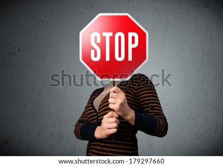 Young lady standing and holding a stop sign in front of her head