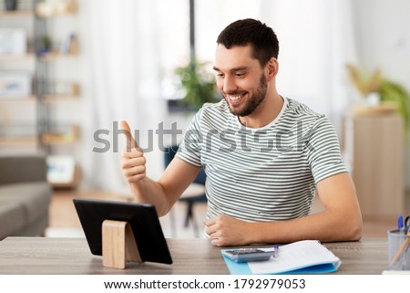 technology, remote job and business concept - man with tablet pc computer having video call and working at home office