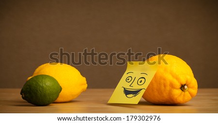 Lemon with sticky note looking happy at citrus fruits