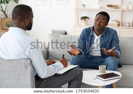 Stressed black man explaining his problems to psychologist at individual therapy session at office, copy space Royalty-Free Stock Photo #1793034835