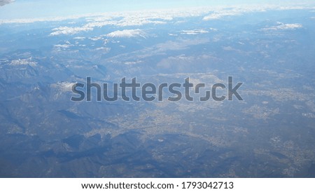 Picture taken from the airplane above a city and mountains