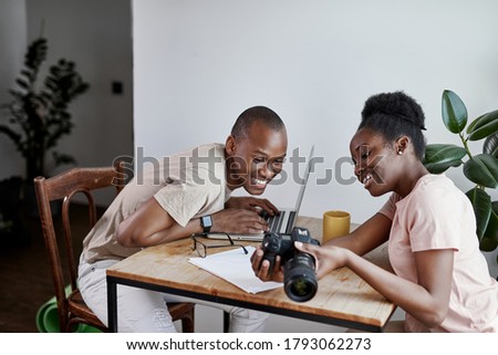 cheerful woman shows photo on camera to her husband, they have conversation and discuss. at home