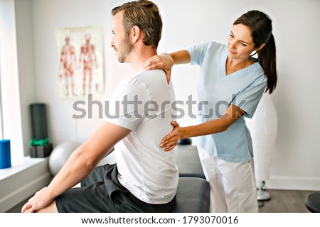 A physiotherapist doing treatment with patient in bright office Royalty-Free Stock Photo #1793070016