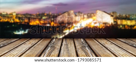 empty wooden table on the background of the night city, panoramic image