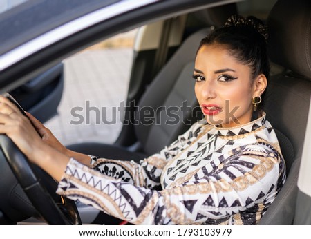 latin woman driving car inside