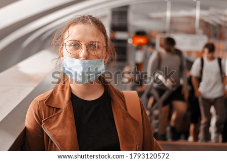 A woman in the wrong medical mask is standing in the subway. The protective mask is not properly worn on the face of a woman in transport Royalty-Free Stock Photo #1793120572