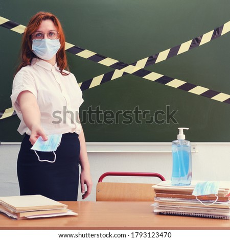 Female teacher gives a medical mask. Distribution of protective medical supplies during coronavirus quarantine