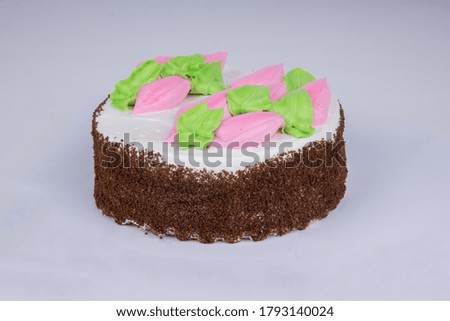 delicious sponge cake with pink and white icing, decorated with cream petals on a white background