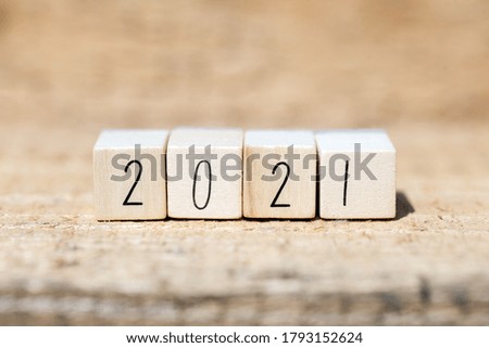 The year 2021 written on wooden cubes, New Years concept or greeting card. wooden background closeup