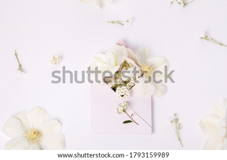 White romantic holiday flowers, clematis, pink envelope full of flowers, wedding, love concept