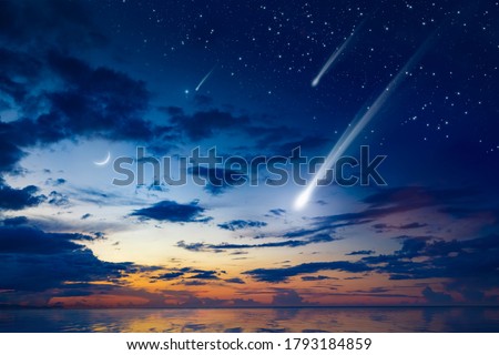 Amazing heavenly image with beautiful glowing sunset, comet and shooting stars, rising crescent moon and bright stars above sea. Elements of this image furnished by NASA Royalty-Free Stock Photo #1793184859