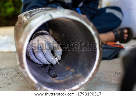 Male worker inspection ultrasonic thickness pipe steel material caused by rust Old rusted iron background concepts, Male hand close-up copying area