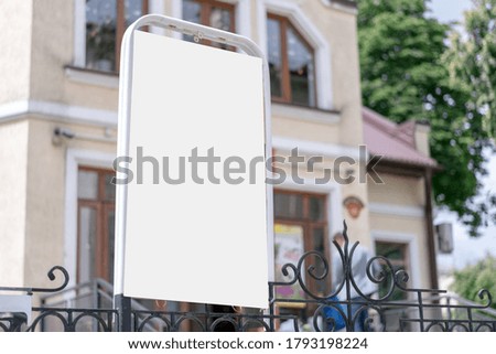 stand with blank white mock-up on black iron fence building facade background outdoor