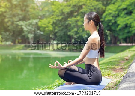 calmness and relax,asian women meditates while practicing yoga in park outdoor. freedom concept.woman happiness. toned picture healthy life