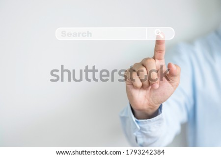Searching information network concept with copy space ,  Businessman using hand input keyword and click to virtual internet search page computer touch screen.