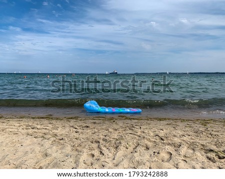 Stunning Baltic Sea sandy beach landscape with blue swimming mattress on warm summer day