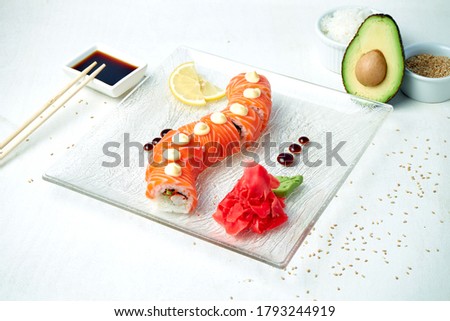 Sushi roll golden dragon with salmon and shrimp on a white background
