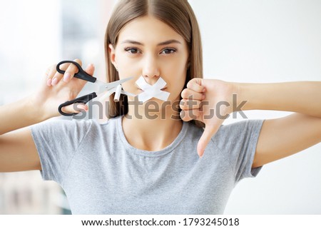Stop smoking, a woman with a sealed mouth cuts a cigarette with scissors