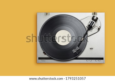 Vinyl player with long play or LP record on yellow background. Top view, copy space.