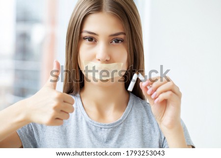 Stop smoking, a young woman with a sealed mouth holding a broken cigarette