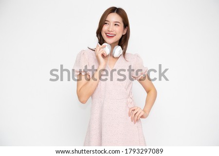 Young Asian woman listening music with headphones isolated on white background