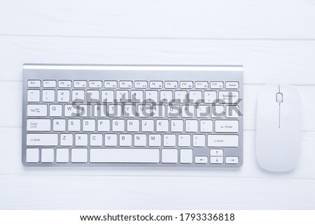 Computer keyboard and mouse on wooden table