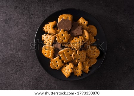 Funny Halloween cookies on black background. Top view