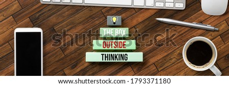 boxes with text THINKING OUTSIDE THE BOX amd computer equipment on wooden background