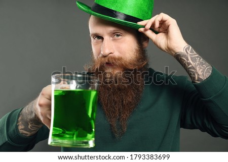 Man with green beer on grey background. St. Patrick's Day celebration