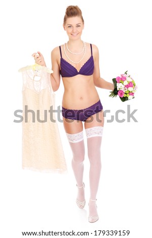A picture of a bride holding flowers and dress and wearing underwear over white background