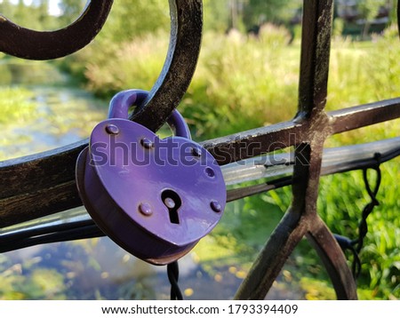The heart-shaped lock is attached to a wrought-iron bridge. Reservoir in the background.