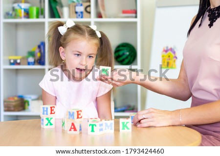 developmental and speech therapy classes with a child-girl. Speech therapy exercises and games with letters. dice game Royalty-Free Stock Photo #1793424460