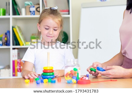 developmental and speech therapy classes with a child-girl. Speech therapy exercises and games with a colored pyramid