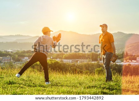Father and son playing in baseball. Playful Man teaching Boy baseballs exercise outdoors in sunny day at public park. Family sports weekend. Father's day.