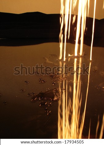 fire trails in dark and falling on reflective surface