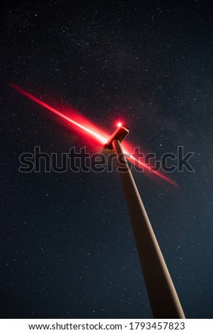 Night photo of windmill and stars with abstract lighting. 