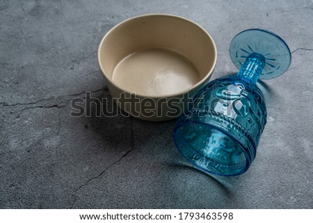 Tableware and decorations for serving a festive table. Plates, wine glasses and cutlery with gray decorative textile on white background.