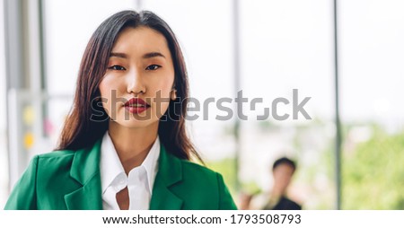 Beautiful smiling confident asian businesswoman in smart casual looking at camara.Young creative coworkers business people working and planning strategy analysis at office