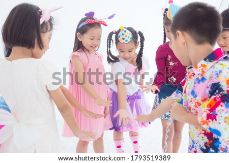 Group of asian children playing games together at birthday party.
