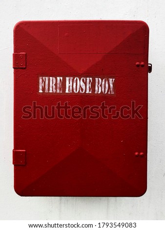 The fire hose box attached on the white wall on a vessel