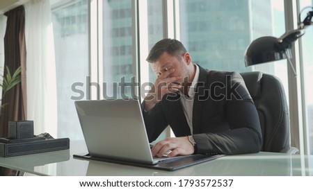 The businessman gets up from the chair and walks to the window. businessman sits thoughtfully in a chair.