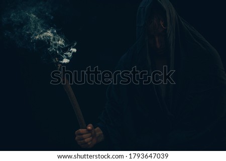 Invisible man in the hood. Smoke. Dark background. Halloween. 