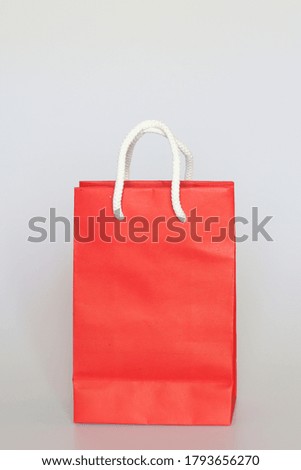 Red paper shopping bag with handle made by white rope isolated on white background.
